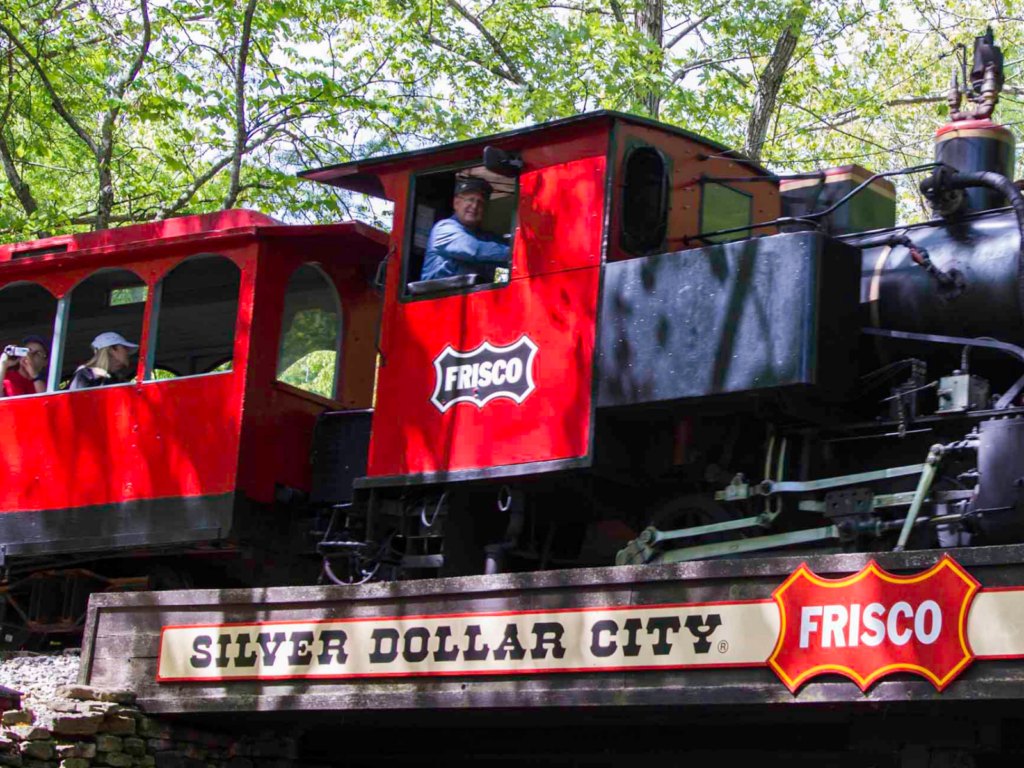 A red Frisco steam locomotive at Silver Dollar City with the park name on a sign across the front