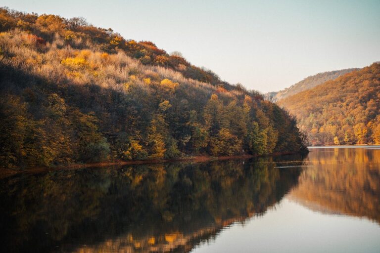 Wooded hillsides in autumn colour reflected in a calm lake