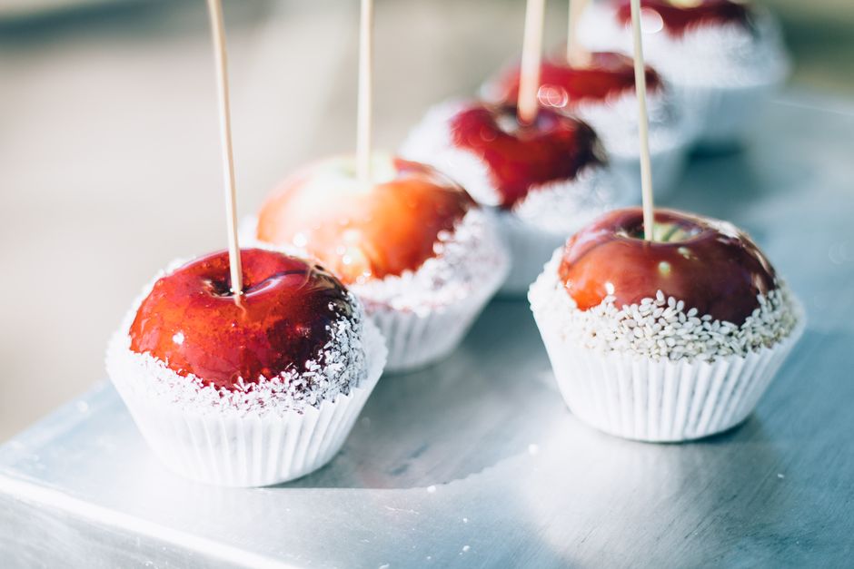 Red candy apples on wooden sticks set in white paper cups